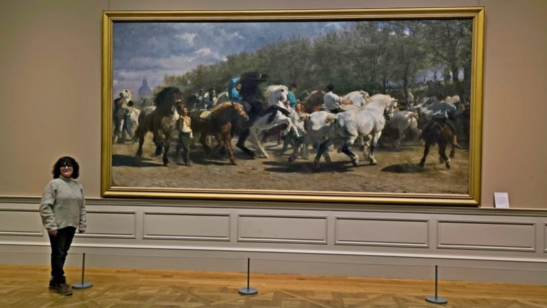 A meeting of scales: Artist Laurence Saunois standing before Rosa Bonheur’s monumental "The Horse Fair" at the MET, New York.