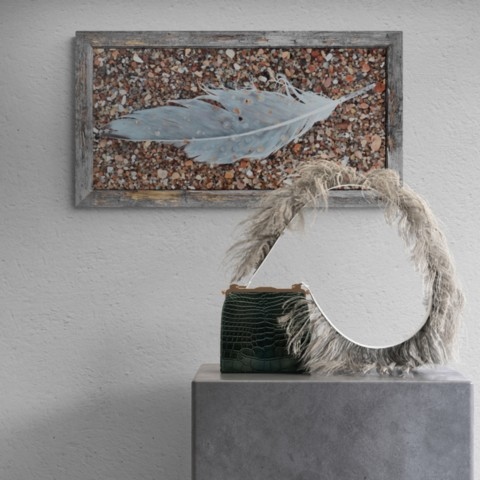  Bird feather on the sand painting wall art decor in a setting above a piece of furniture by wildlife artist Laurence Saunois