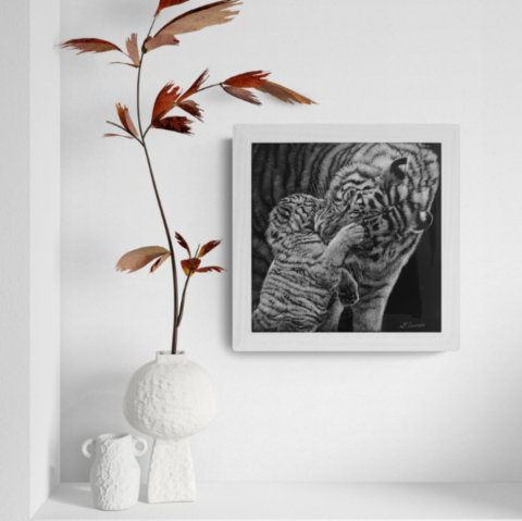 “Scratchboard of a tigress and her cub displayed in a living room setting with a vase – wildlife artist Laurence Saunois